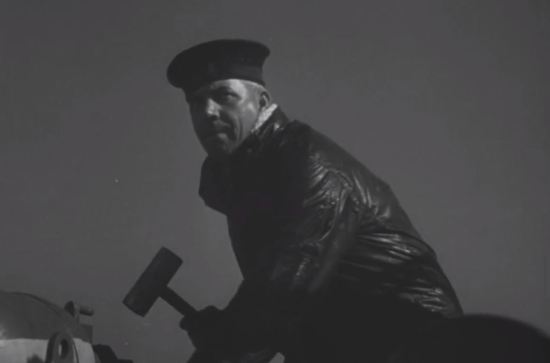 A crewman stands by to fire a torpedo.